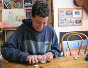 Jongen lachend bezig iets te maken van klei 